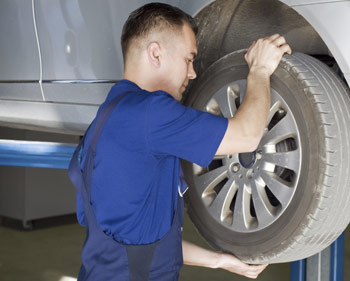 Technician checking the suspension of the vehicle on the lift